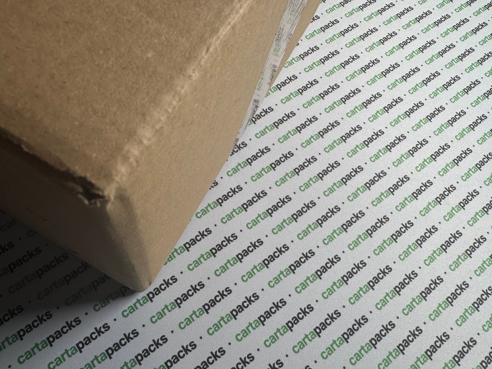 A kraft shipping box sitting on a cartapacks-branded playmat.